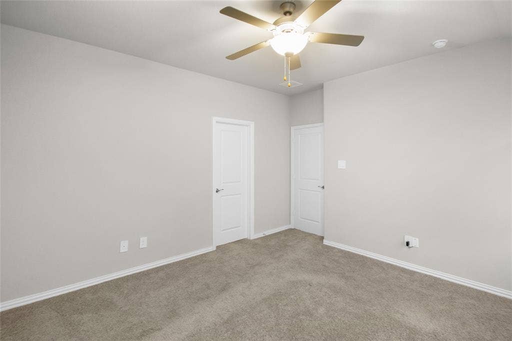 614 Martell Road, Lowry Crossing, TX 75069 Neutral-toned interior space featuring plush wall-to-wall carpeting, two interior doors, and a ceiling fan with integrated lighting