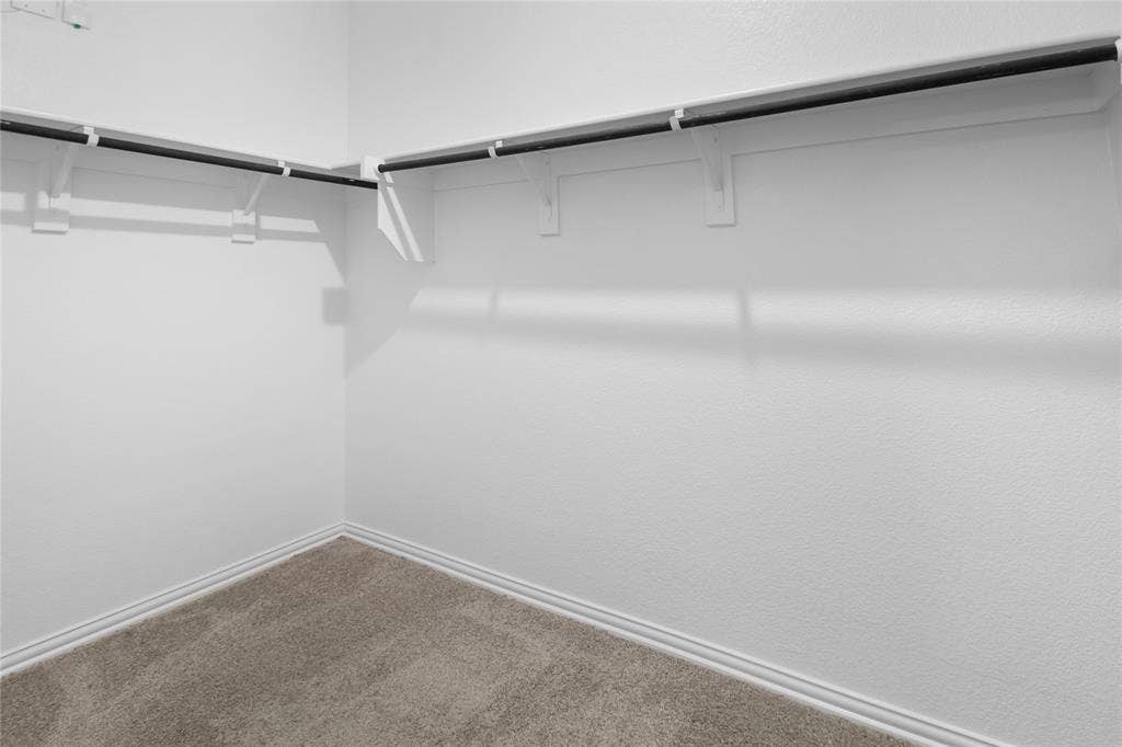 614 Martell Road, Lowry Crossing, TX 75069 Walk-in storage space featuring neutral carpeting and built-in shelving with integrated hanging rods