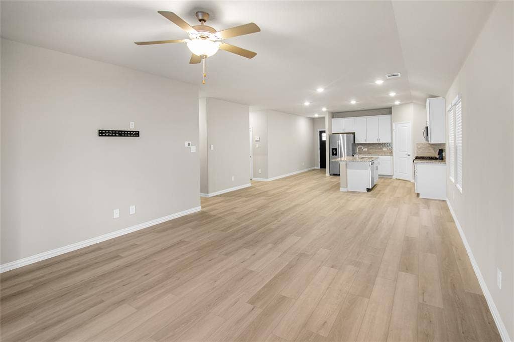 614 Martell Road, Lowry Crossing, TX 75069 Open-concept interior featuring wood-finish flooring, recessed lighting, a ceiling fan, and a kitchen equipped with white cabinetry and a center island