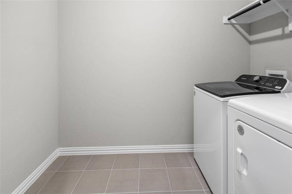 614 Martell Road, Lowry Crossing, TX 75069 Utility room featuring neutral-toned tile flooring and wall-mounted storage shelving