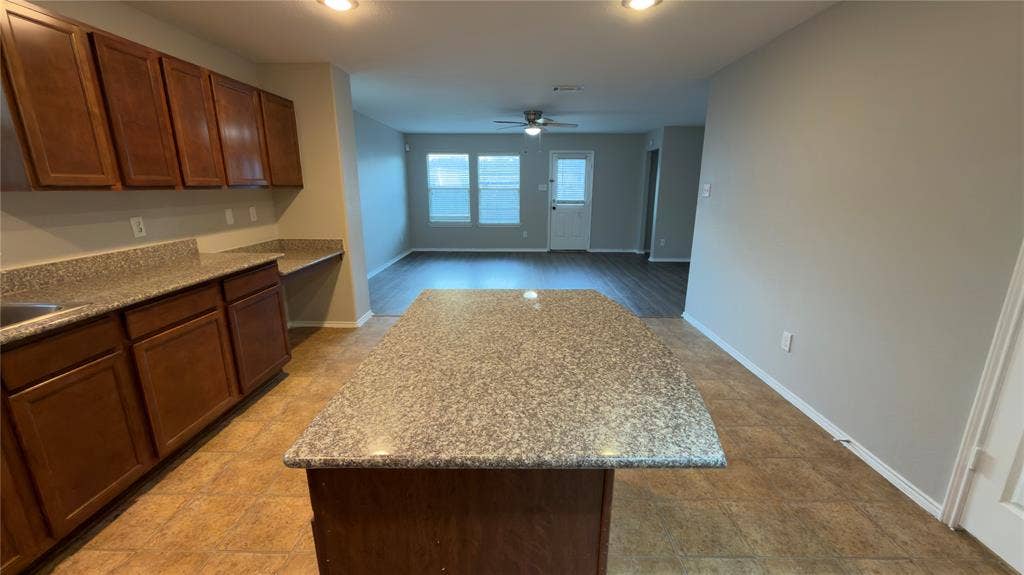 8808 Irish Bend Drive, Fort Worth, TX 76123 Kitchen featuring wood cabinetry, stone-surface countertops, central island, and recessed lighting