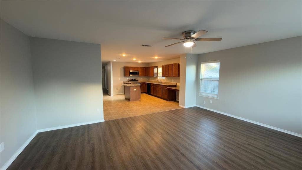 8808 Irish Bend Drive, Fort Worth, TX 76123 Open-concept interior featuring wood-finish flooring, a kitchen island, recessed ceiling lighting, and a ceiling fan