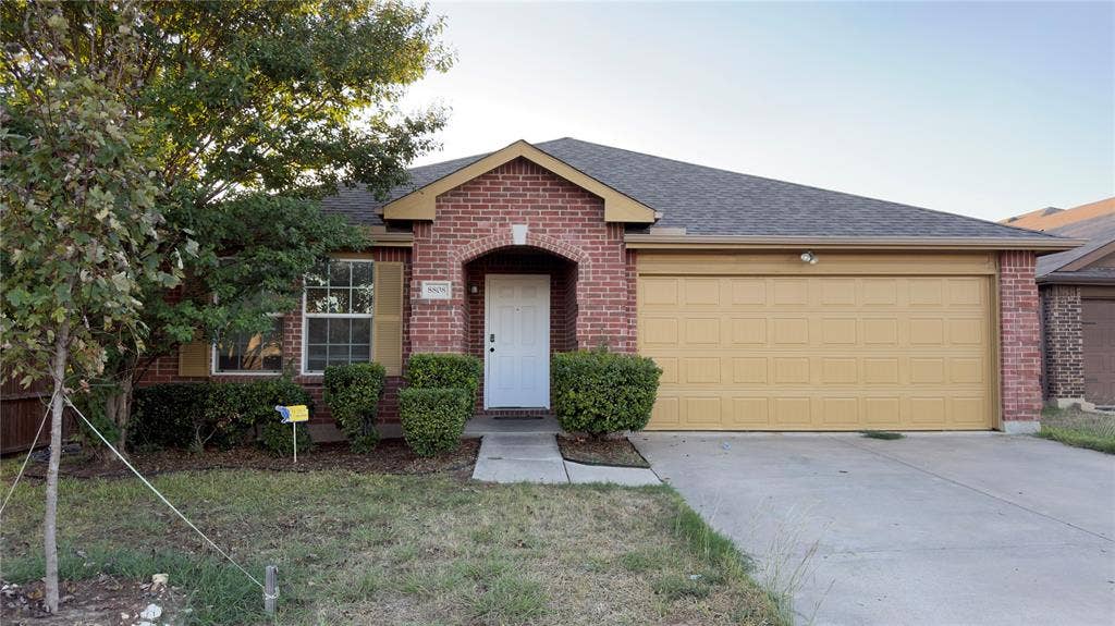 8808 Irish Bend Drive, Fort Worth, TX 76123 Brick exterior featuring a gabled roofline, covered entryway, and an attached two-car garage