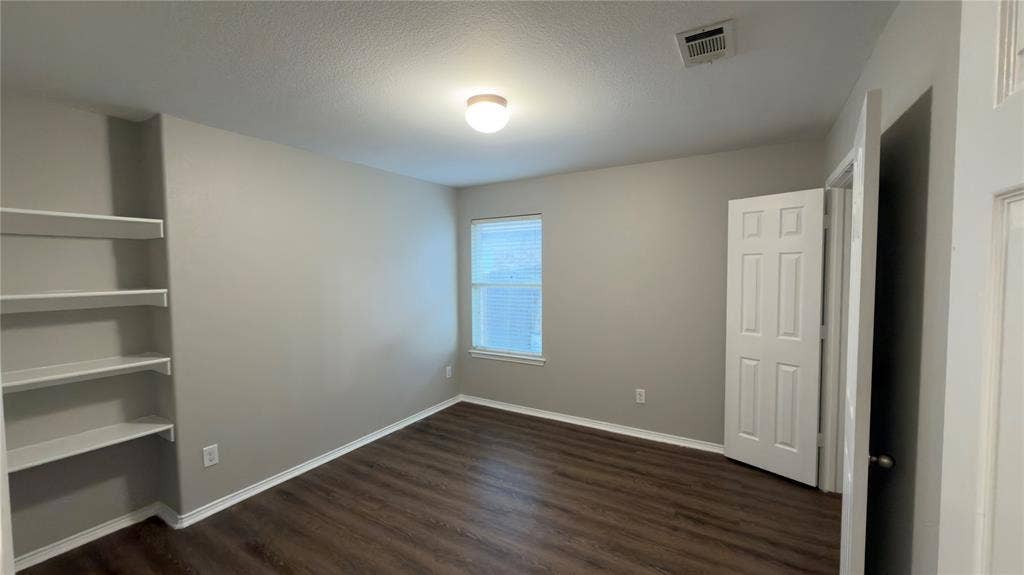8808 Irish Bend Drive, Fort Worth, TX 76123 Interior room featuring wood-finish flooring, built-in shelving, a recessed window, and a six-panel door
