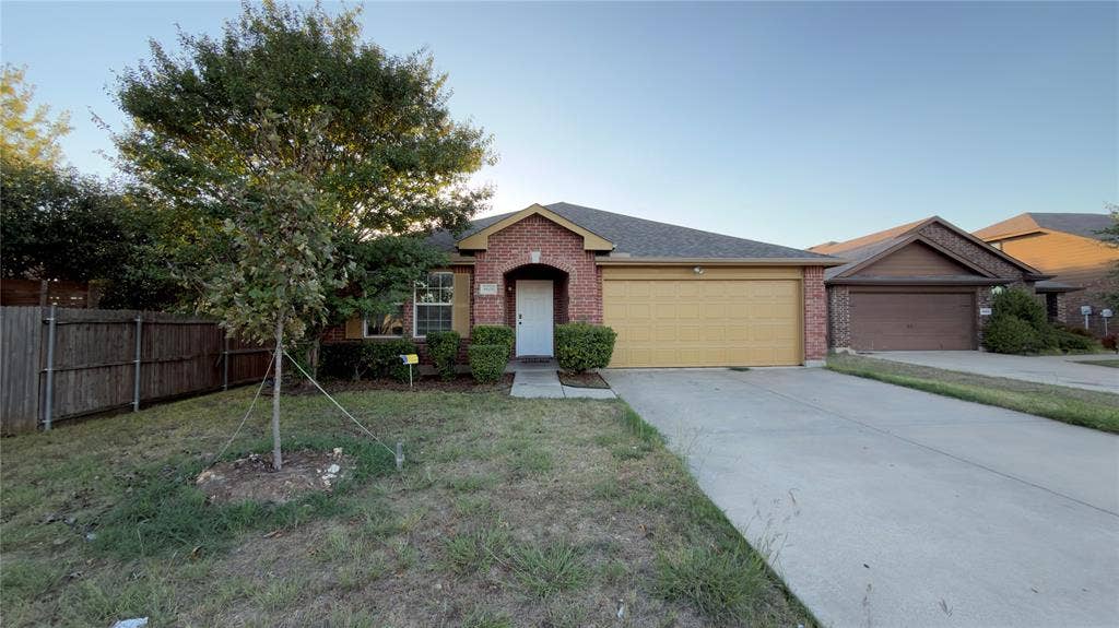 8808 Irish Bend Drive, Fort Worth, TX 76123 Single-story exterior featuring a brick facade, gabled roofline, concrete driveway, attached garage, and wood fencing