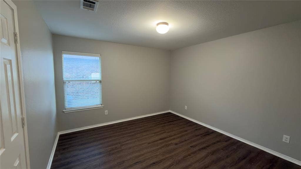 8808 Irish Bend Drive, Fort Worth, TX 76123 Room featuring wood-finish flooring, neutral wall paint, a single window with blinds, and a ceiling-mounted light fixture