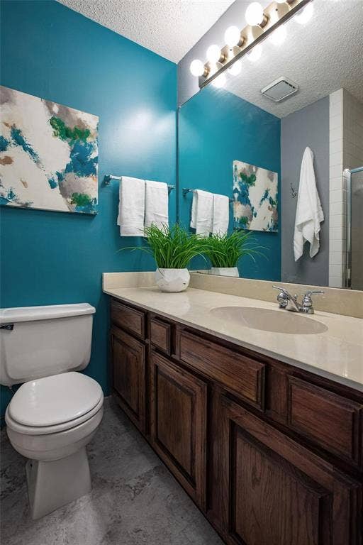 Bathroom featuring a stone-composite countertop, dark wood-finish cabinetry, an oval integrated sink, a full-width vanity mirror, and an eight-bulb Hollywood-style light fixture