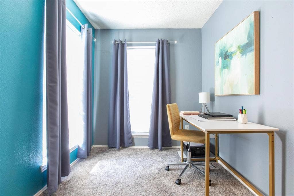 Room featuring dual-tone painted walls, neutral carpeting, and two expansive windows