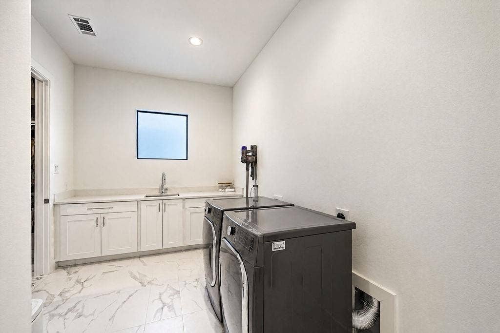 4515 Cowan Avenue, Dallas, TX 75209 A spacious laundry room includes lower cabinetry for detergent storage and room to fold without feeling cramped