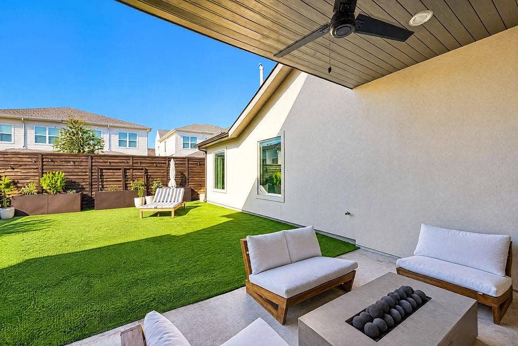 4515 Cowan Avenue, Dallas, TX 75209 Stackable sliding glass doors pull back to connect the indoor living room directly to a covered outdoor patio fitted with a ceiling fan