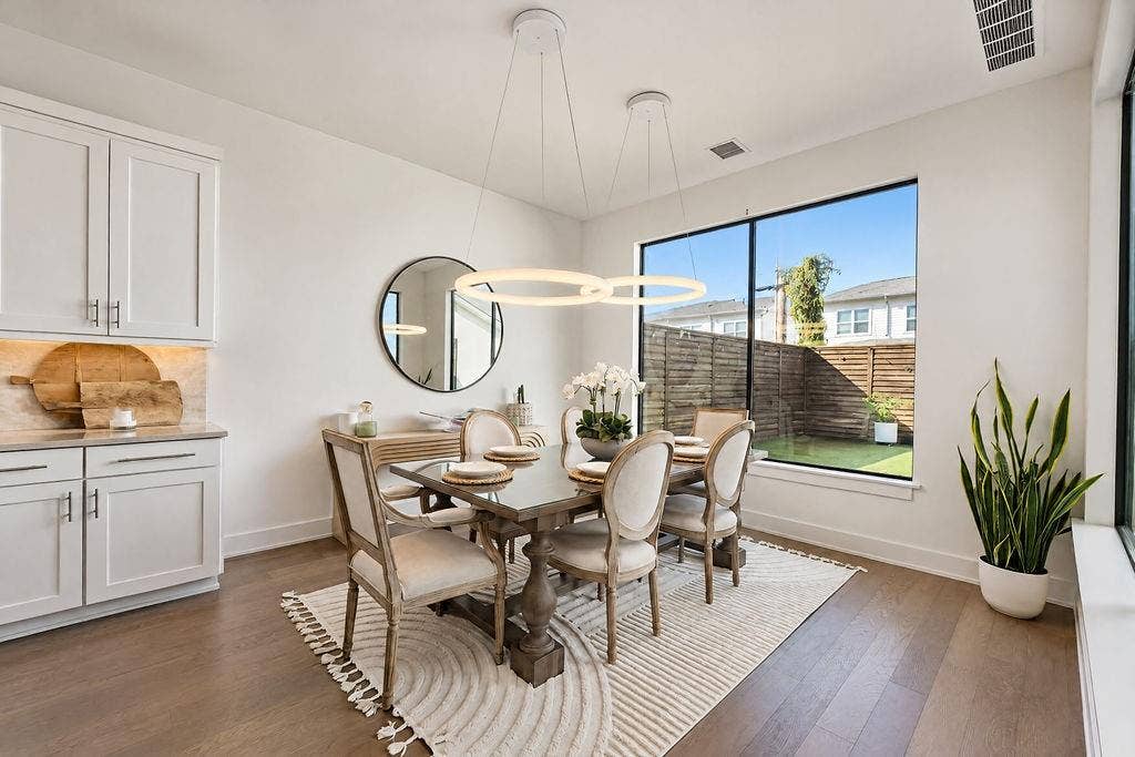 4515 Cowan Avenue, Dallas, TX 75209 The dining area comfortably hosts dinner parties, positioned right under a custom chandelier with views out to the backyard