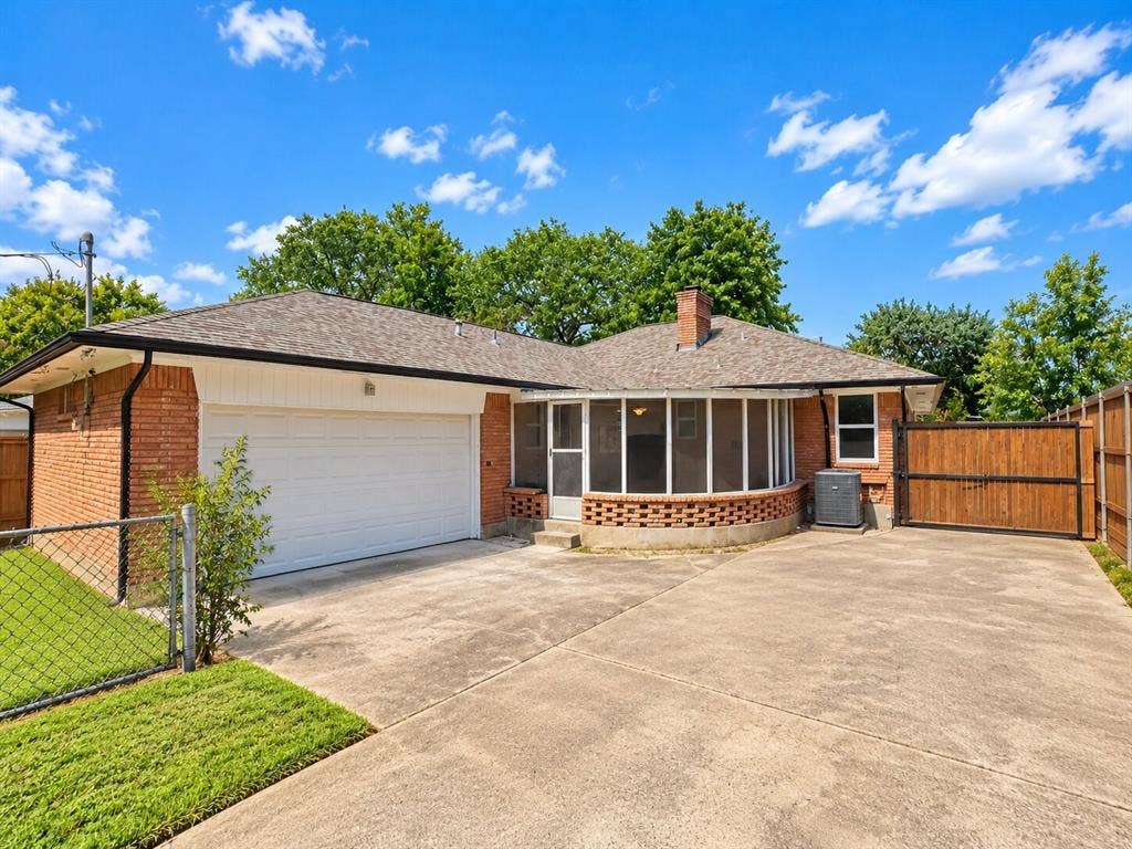 2551 Pinebluff Drive, Dallas, TX 75228 Brick exterior featuring an attached two-car garage, enclosed porch with a masonry base, concrete driveway, and wood privacy fencing