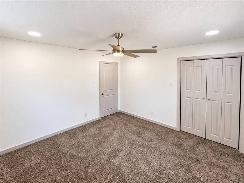 2551 Pinebluff Drive, Dallas, TX 75228 Neutral-toned carpeting, recessed ceiling lighting, a brushed-nickel ceiling fan, and paneled closet doors