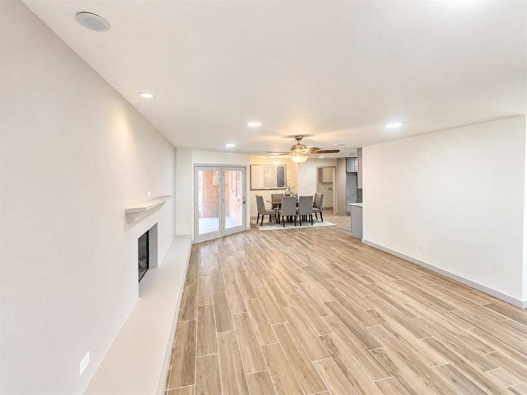 2551 Pinebluff Drive, Dallas, TX 75228 Open floor plan featuring wood-finish flooring, recessed lighting, a fireplace with a mantel, and double doors opening to an exterior area