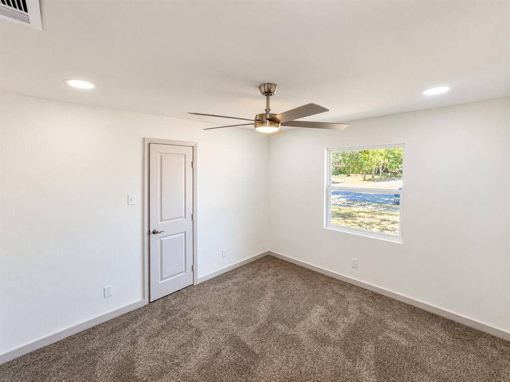 2551 Pinebluff Drive, Dallas, TX 75228 Room featuring neutral wall-to-wall carpeting, recessed ceiling lighting, a centrally located brushed-nickel ceiling fan with integrated light kit, and a single-panel interior door