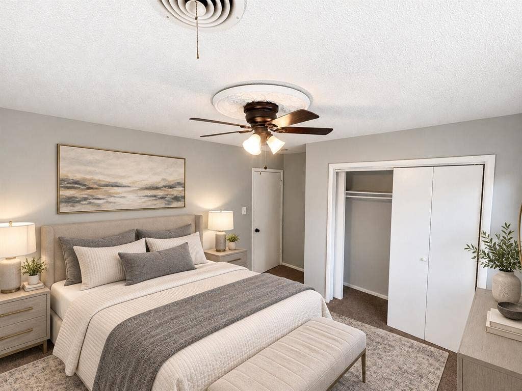 Ceiling fan with ornate decorative medallion, neutral wall paint, and double-door reach-in closet