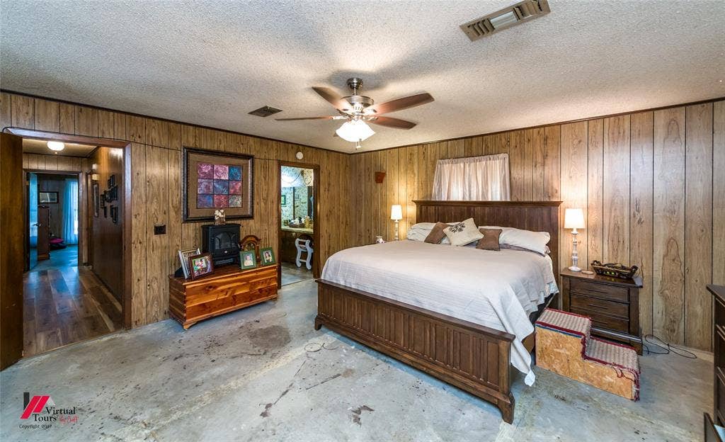 Wood-panelled wall treatments, ceiling-mounted light fixture with integrated fan, and multiple doorways