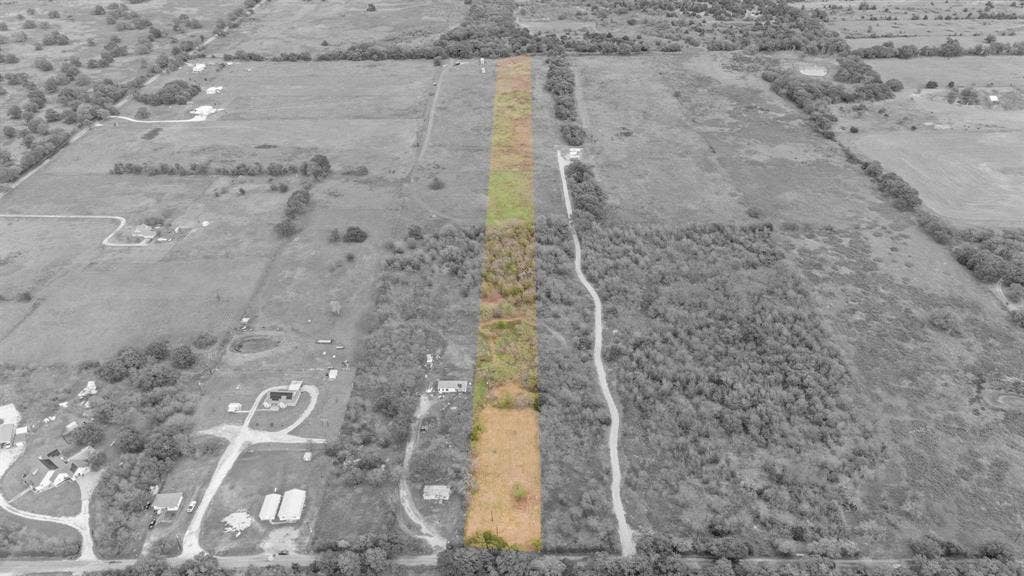 870 Wagoner Road, Waco, TX 76705 Expansive acreage featuring cleared land, mature tree clusters, and direct access to an established gravel path