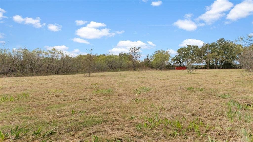 870 Wagoner Road, Waco, TX 76705 Expansive open acreage featuring native grasses, scattered mature trees, and a perimeter fence line