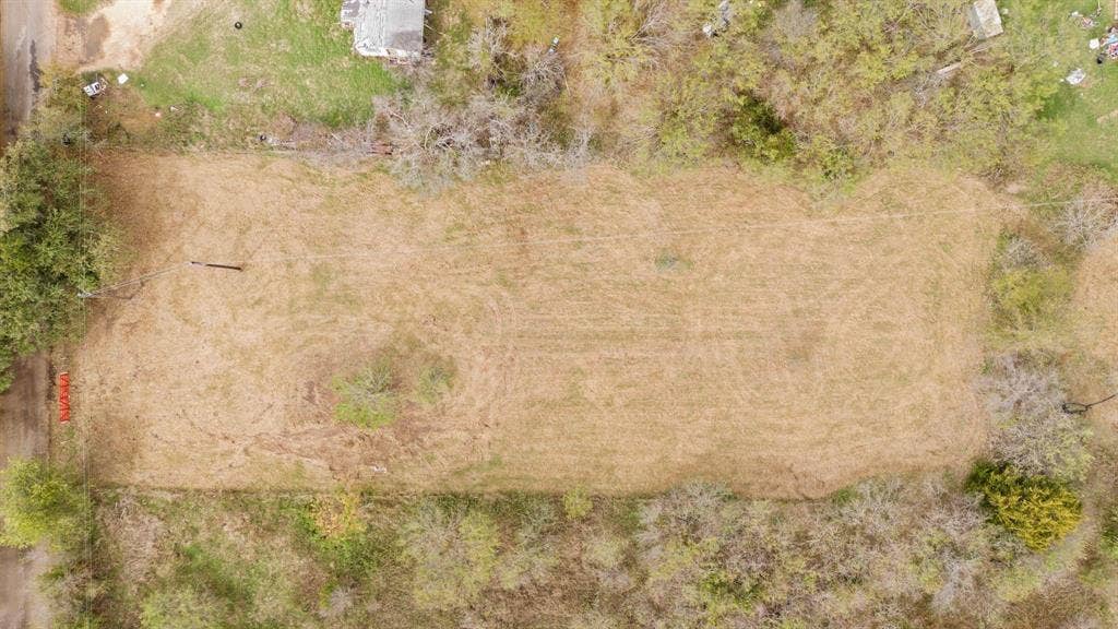 870 Wagoner Road, Waco, TX 76705 Expansive rectangular lot featuring level terrain, cleared ground, and mature perimeter trees