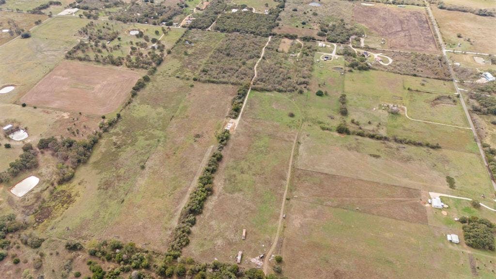 870 Wagoner Road, Waco, TX 76705 Expansive rural acreage featuring cleared pasture land, mature tree clusters, and established dirt access paths