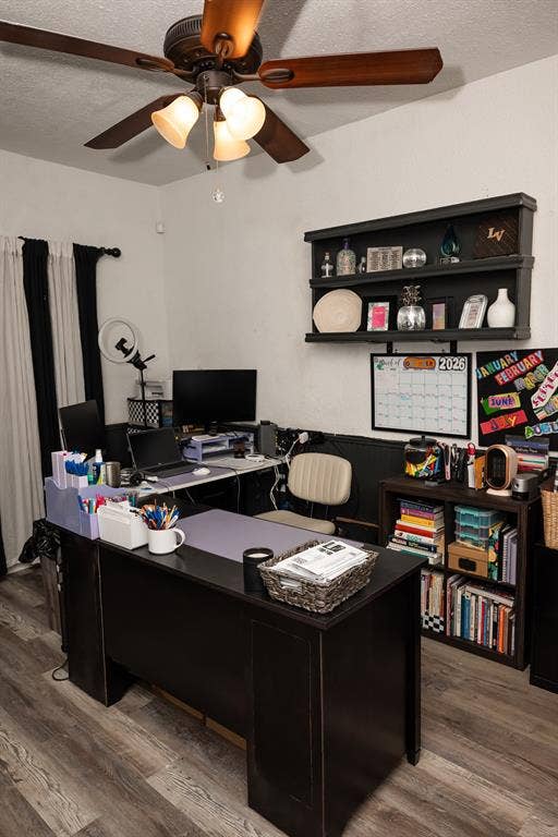 Wood-finish flooring, ceiling fan with three-light fixture, and wall-mounted shelving