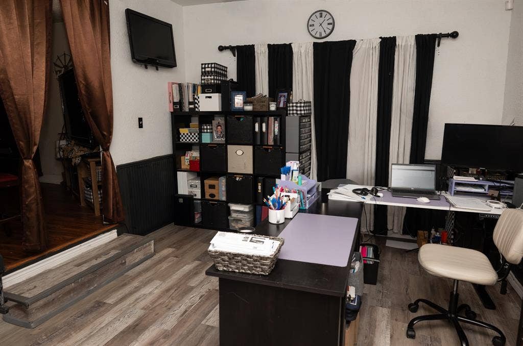 Wood-finish flooring, vertical wainscoting, and a raised platform step