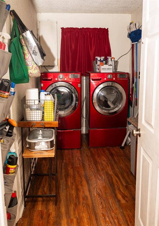 Dedicated utility space featuring wood-finish flooring and front-load laundry appliances