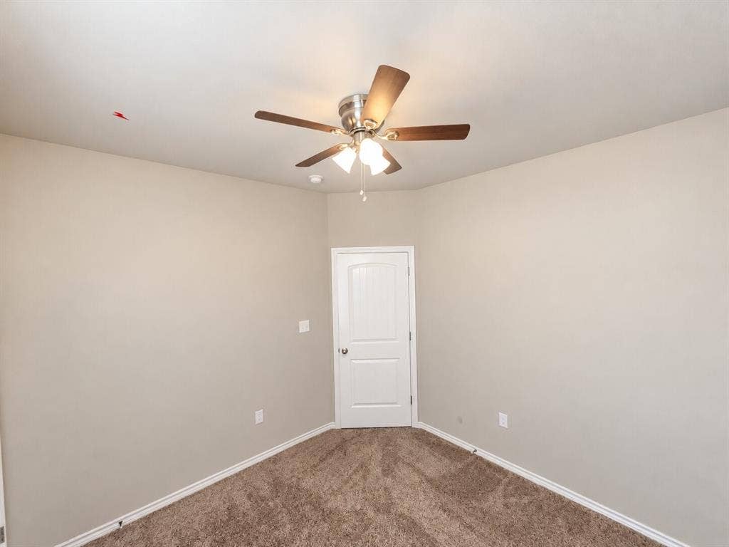 1306 Campbelton Drive, Temple, TX 76504 Neutral-toned interior space featuring wall-to-wall carpeting, a multi-blade ceiling fan with integrated lighting, and a solid-core, two-panel interior door