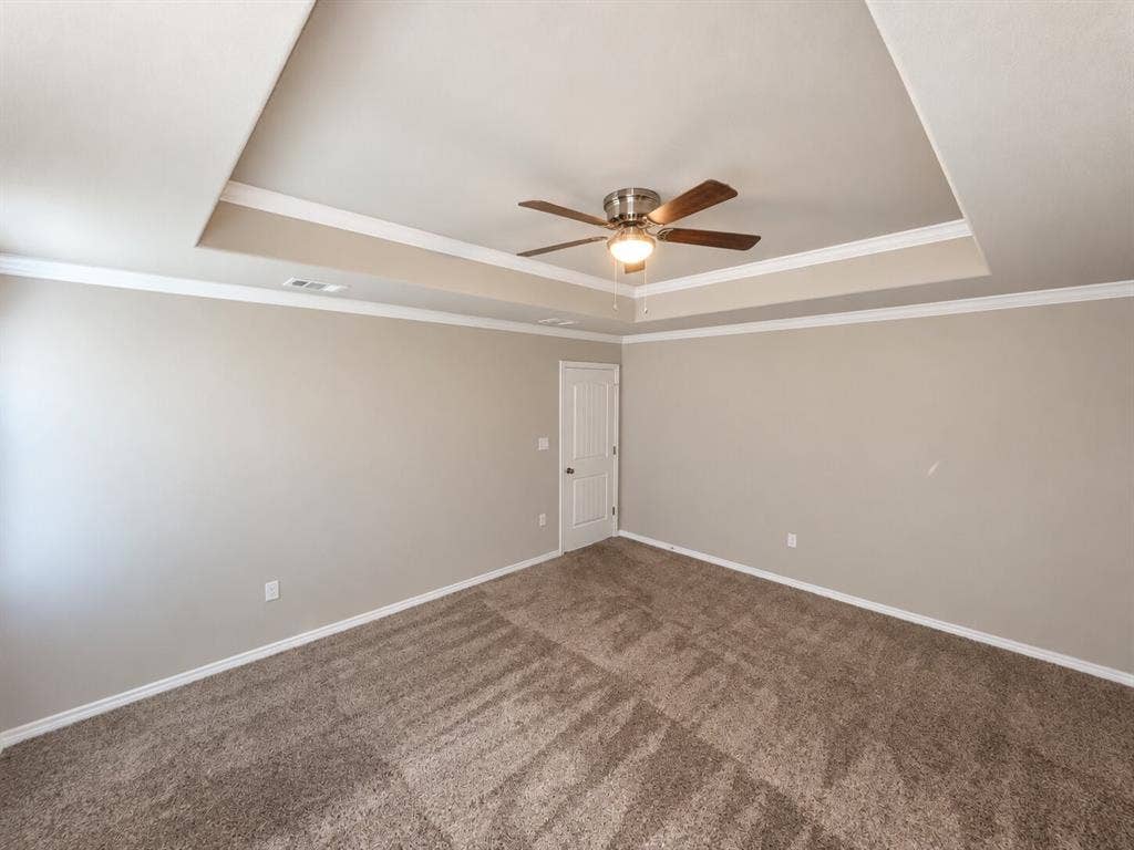 1306 Campbelton Drive, Temple, TX 76504 Tray ceiling featuring crown molding, neutral wall color, carpeting, and a multi-blade ceiling fan with a central light fixture