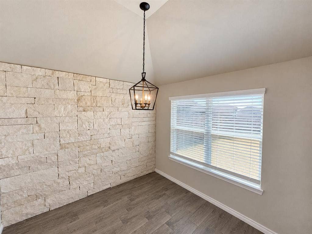 1306 Campbelton Drive, Temple, TX 76504 Vaulted ceilings, textured stone accent wall, wood-finish flooring, and a multi-light geometric pendant fixture