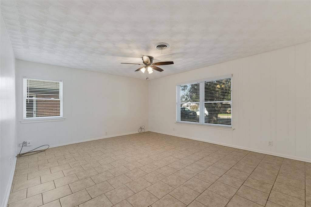 11038 Wyatt, Dallas, TX 75218 Neutral-toned ceramic tile flooring, multi-light ceiling fan, and large windows with horizontal blinds