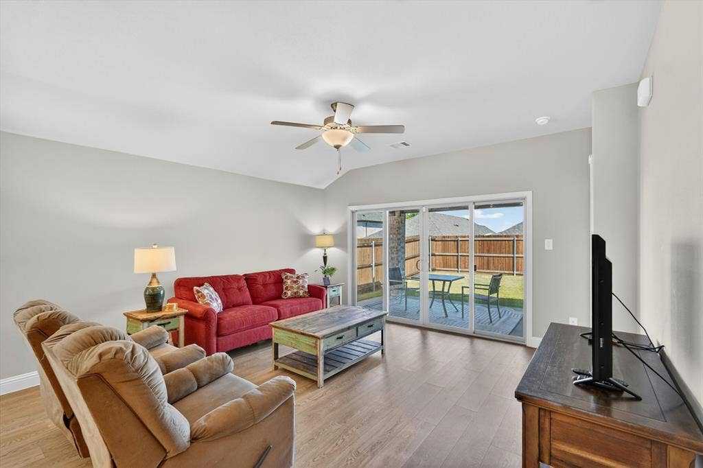 903 Edgehurst Drive, Princeton, TX 75071 Open concept living area featuring wood-finish flooring, light gray walls, and a vaulted ceiling with a ceiling fan