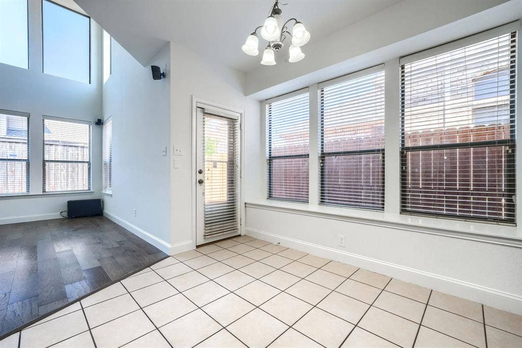 1127 Valley Vista Drive, Irving, TX 75063 Tall vaulted ceilings, wood-finish flooring, ceramic tile flooring, multi-light chandelier, and large windows with horizontal blinds