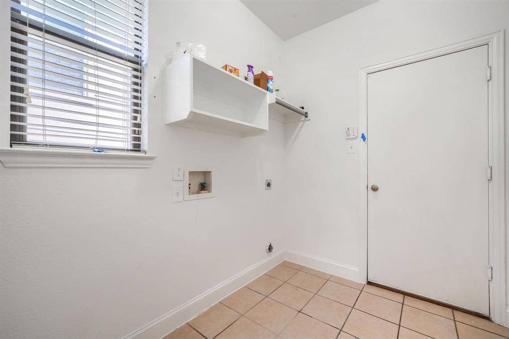 1127 Valley Vista Drive, Irving, TX 75063 Utility room featuring tile flooring, a window with horizontal blinds, built-in white wall-mounted shelving, and a metal hanging rod