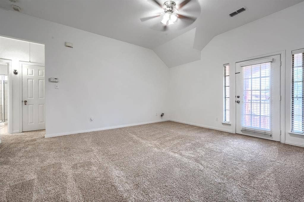 1127 Valley Vista Drive, Irving, TX 75063 Vaulted ceilings, neutral carpeting, ceiling fan with light fixture, and glass-paneled door with flanking side windows