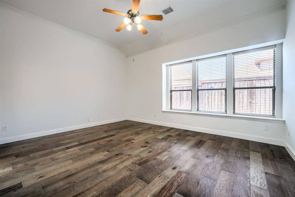 1127 Valley Vista Drive, Irving, TX 75063 Room with vaulted ceilings, wood-finish flooring, a triple-pane window arrangement, and a multi-blade ceiling fan with integrated lighting