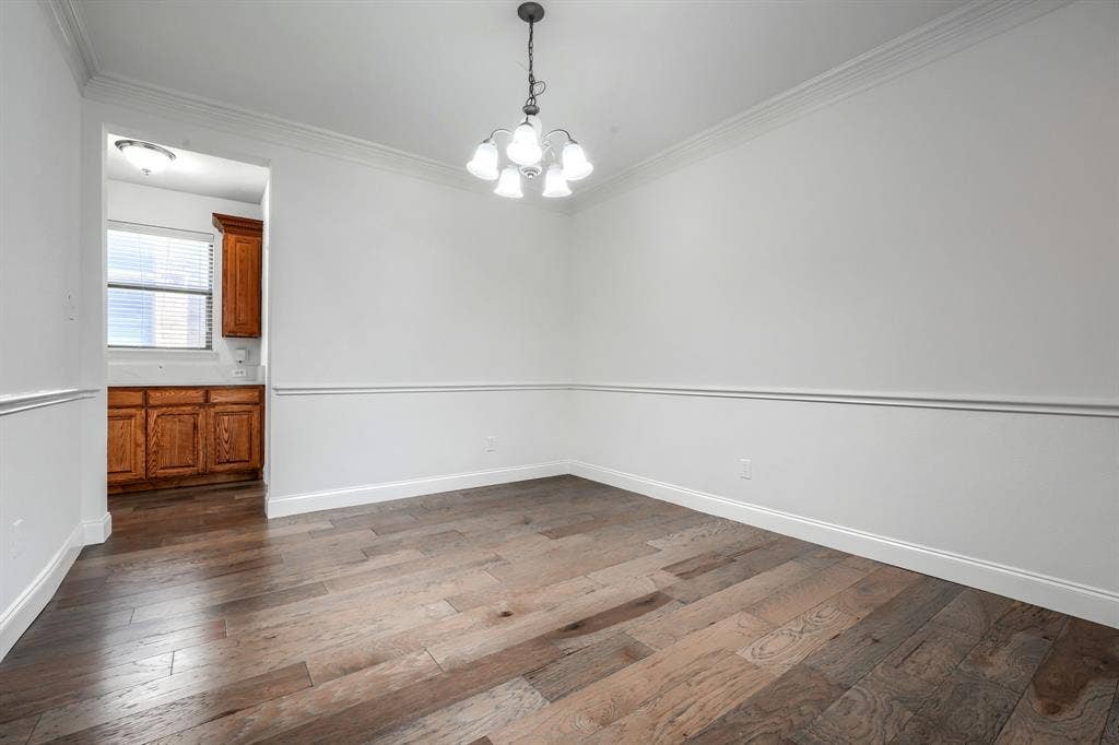1127 Valley Vista Drive, Irving, TX 75063 Room featuring wood-finish flooring, chair rail molding, crown molding, and a five-light chandelier