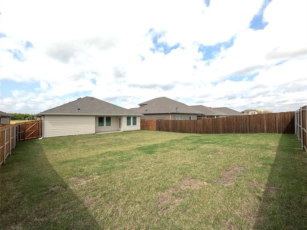 4017 Bronco Drive, Princeton, TX 75407 Expansive backyard featuring a level lawn and full-perimeter wood fencing
