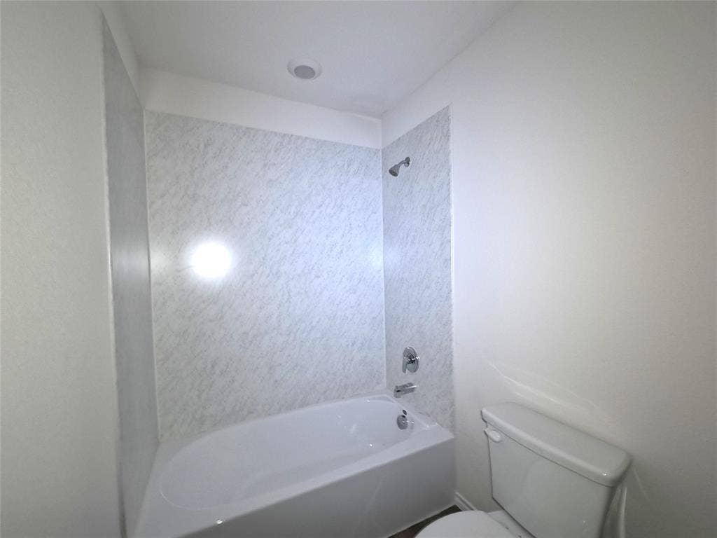 4017 Bronco Drive, Princeton, TX 75407 Bathtub with white surround featuring a marble-patterned finish, chrome shower head, and chrome faucet hardware