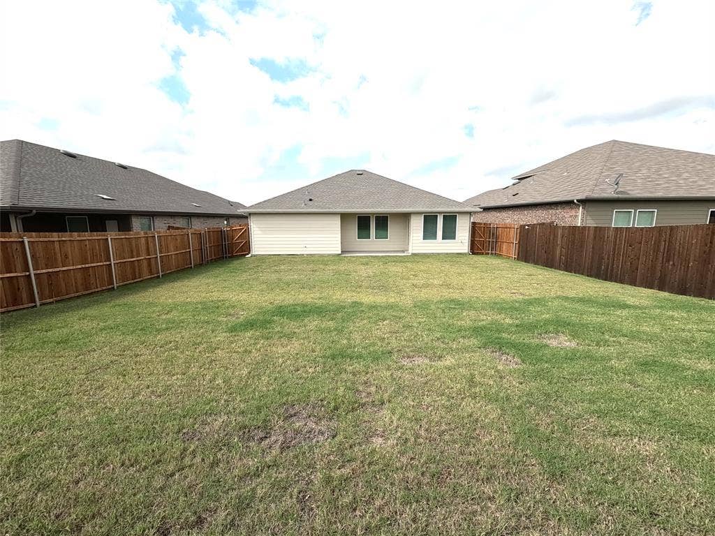 4017 Bronco Drive, Princeton, TX 75407 Backyard featuring a grass lawn, horizontal wood privacy fencing, and neutral-toned siding