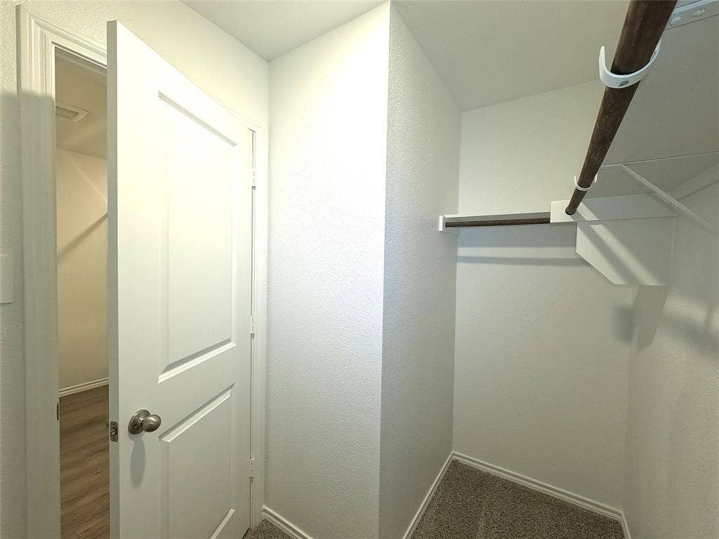 4017 Bronco Drive, Princeton, TX 75407 Walk-in closet featuring carpet flooring, built-in shelving, and a hanging rod