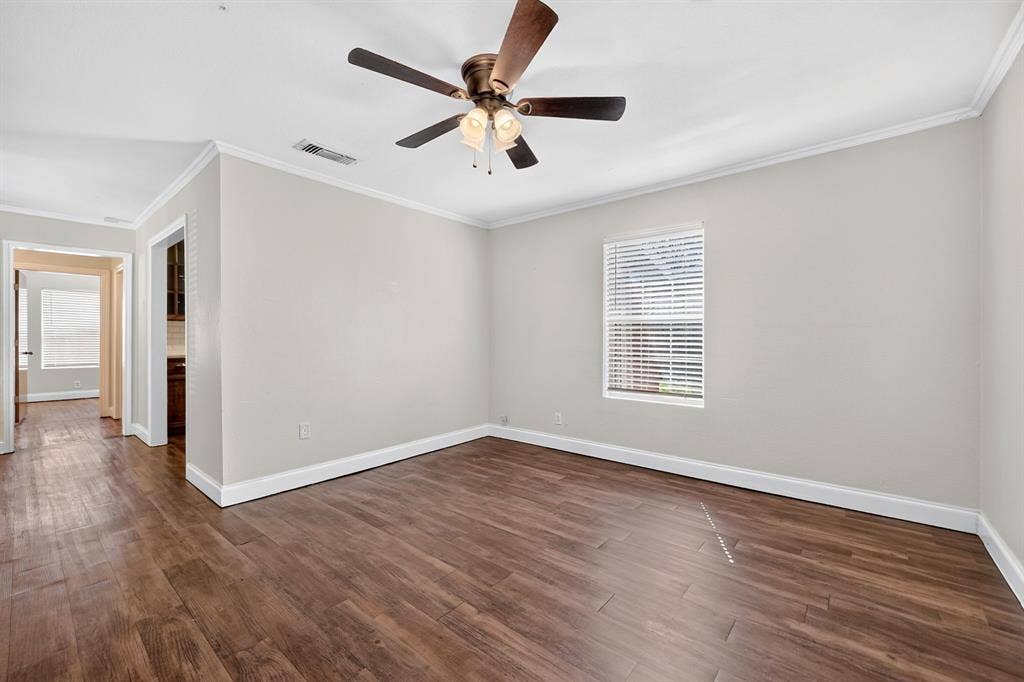 Wood-finish flooring, ceiling fan with integrated lighting, neutral wall paint, and horizontal window blinds