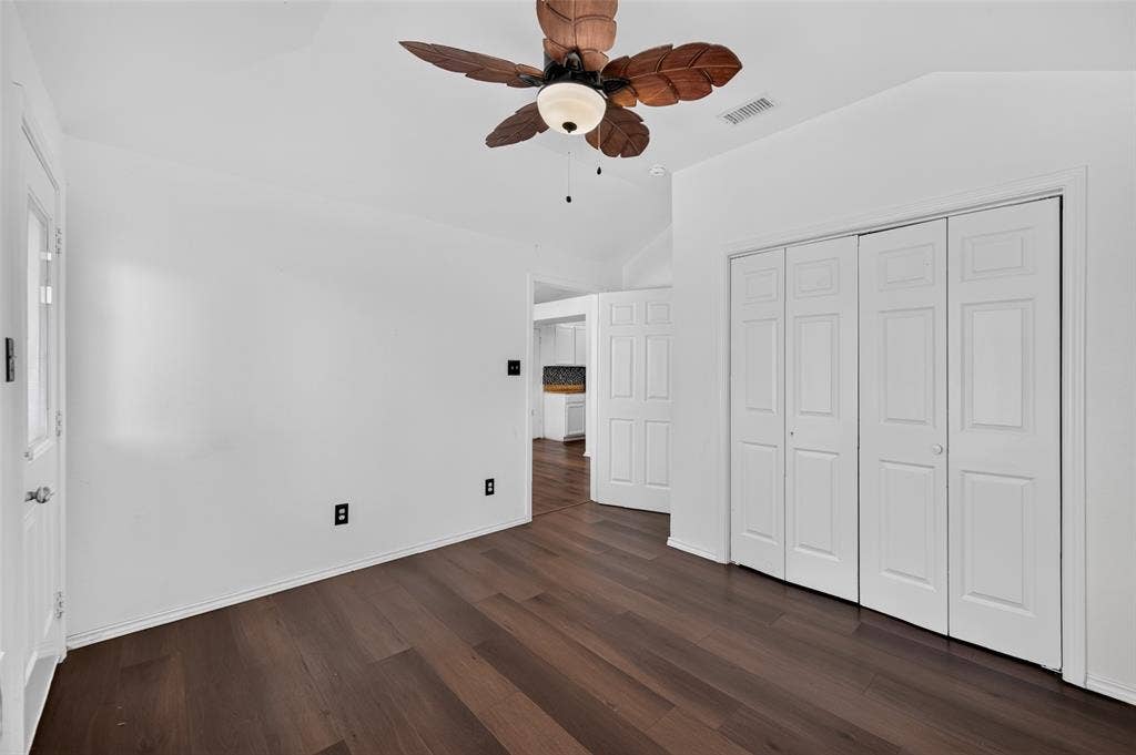 583 Kirkland Drive, Coppell, TX 75019 Vaulted ceiling featuring a ceiling fan, wood-finish flooring, and white bifold closet doors
