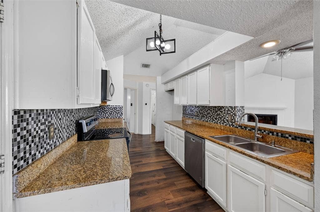 583 Kirkland Drive, Coppell, TX 75019 Kitchen featuring white cabinetry, granite-finish countertops, checkerboard mosaic tile backsplash, wood-finish flooring, and stainless steel appliances