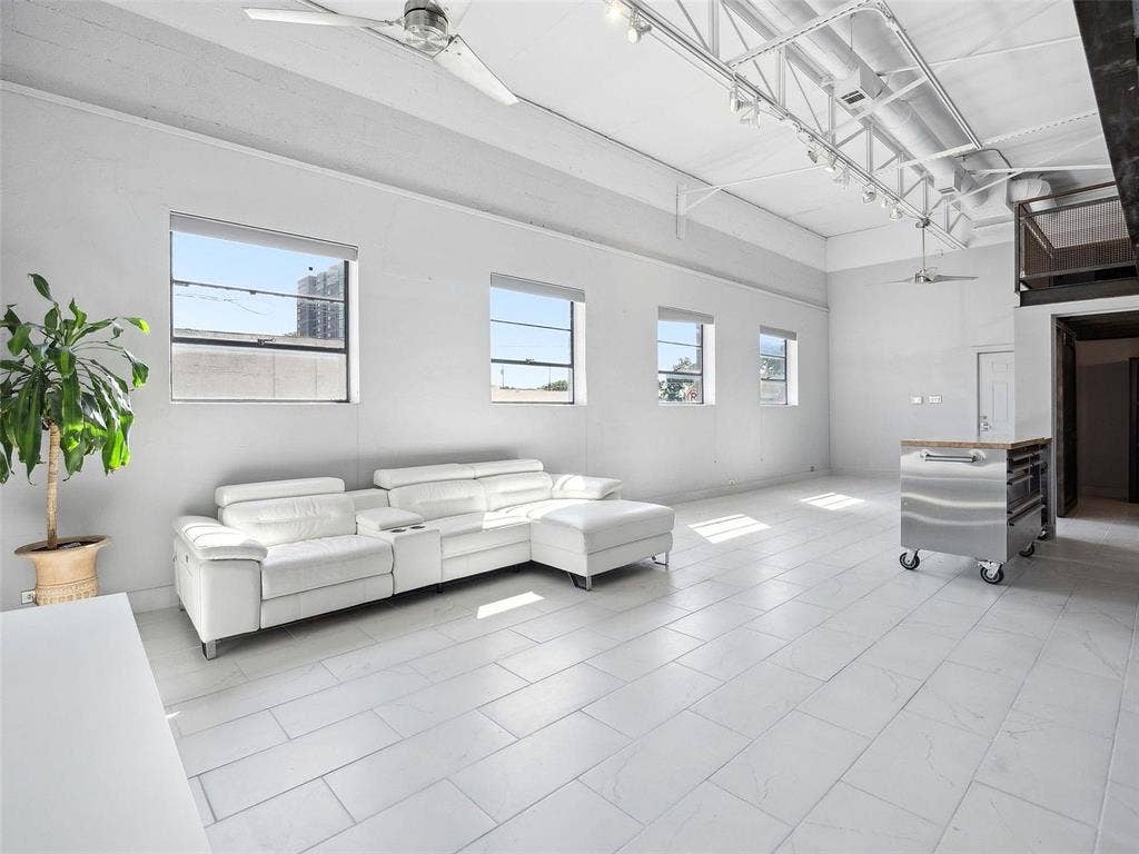 215 N Walton Street, #2, Dallas, TX 75226 Industrial-style interior featuring high ceilings with exposed trusses, large-format tile flooring, oversized windows, and overhead track lighting