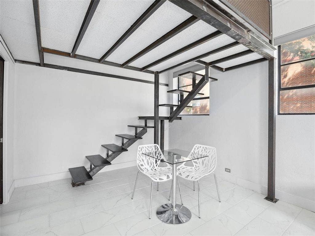 215 N Walton Street, #2, Dallas, TX 75226 Industrial-style metal mezzanine structure featuring exposed steel beams, custom-welded staircase with floating treads, large multi-pane windows, and white tile flooring