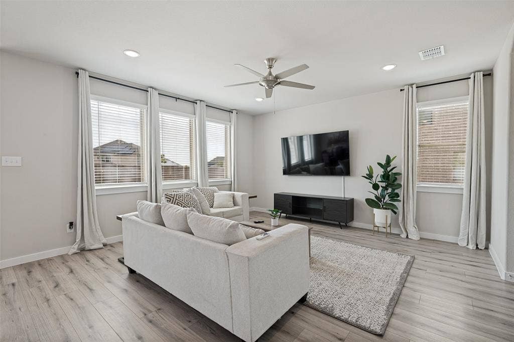 2808 Spring Side Drive, Royse City, TX 75189 Wood-finish flooring, recessed lighting, ceiling fan, and large windows with horizontal blinds