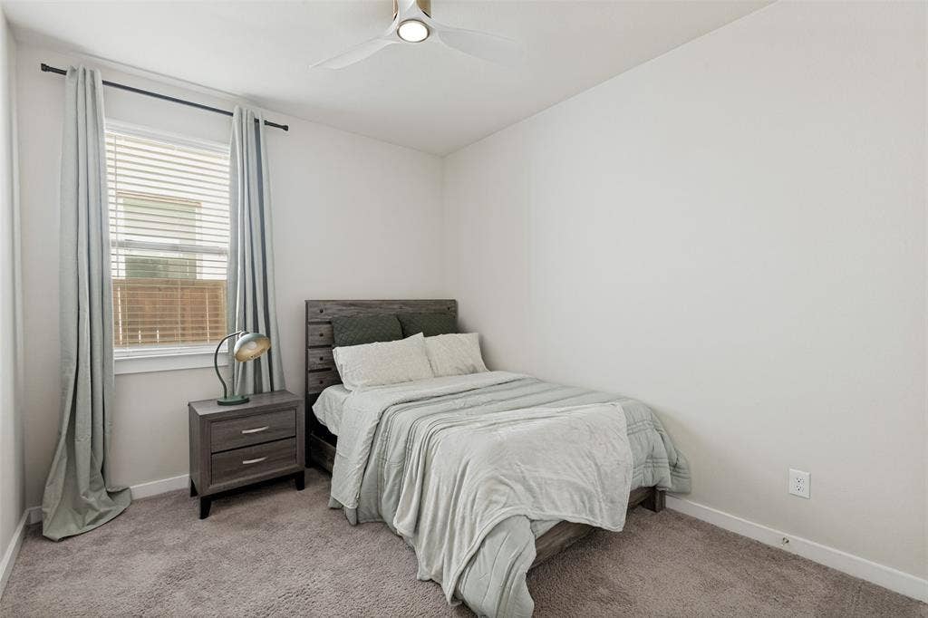 2808 Spring Side Drive, Royse City, TX 75189 Neutral-toned interior featuring wall-to-wall carpeting, window with horizontal blinds, and a ceiling-mounted light fixture with fan blades