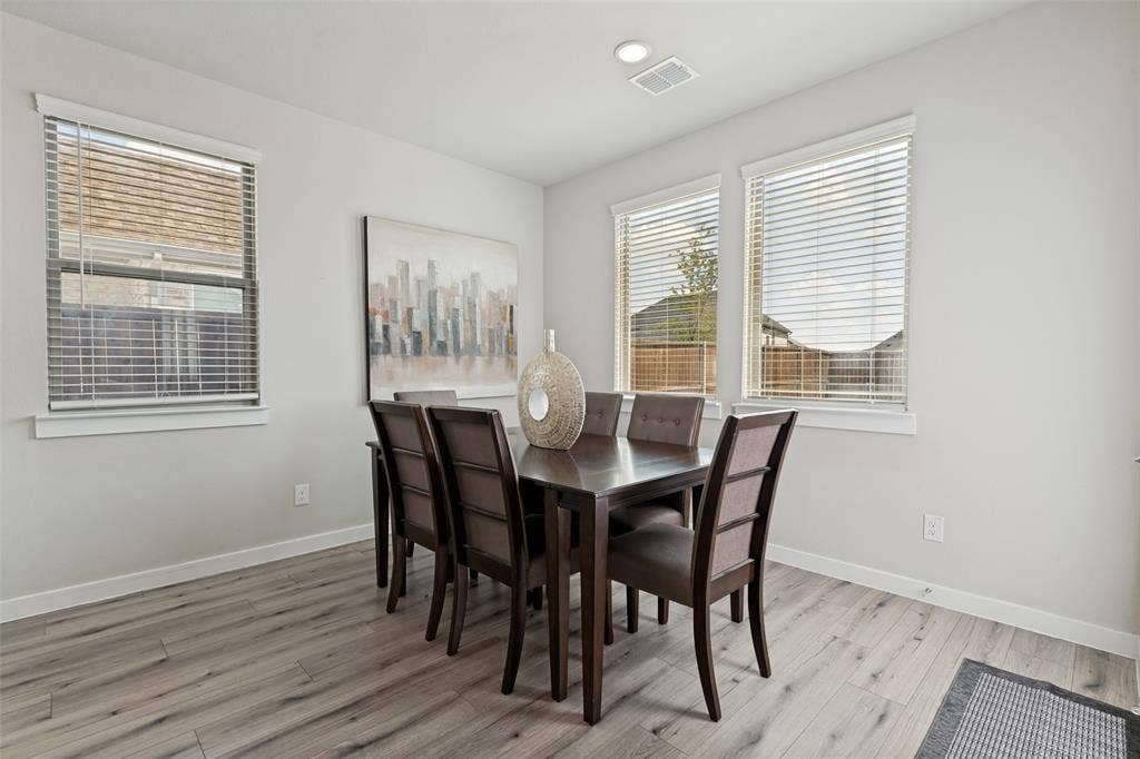 2808 Spring Side Drive, Royse City, TX 75189 Neutral-toned interior space featuring wood-finish flooring, three windows with horizontal blinds, and recessed ceiling lighting